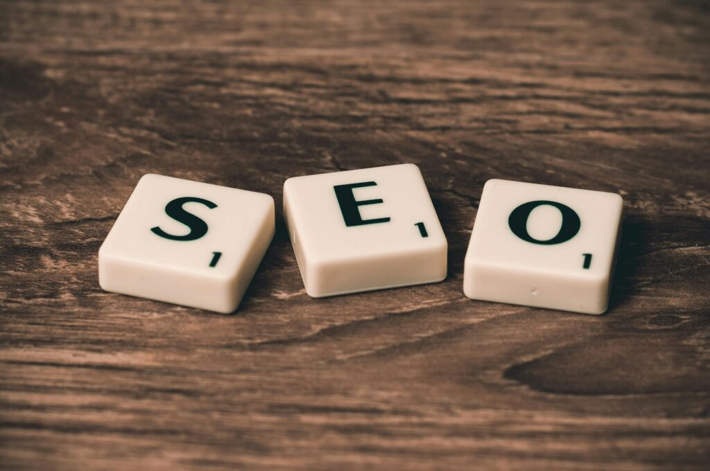 SEO concept displayed using scrabble tiles on a wooden background, representing website search engine optimization.