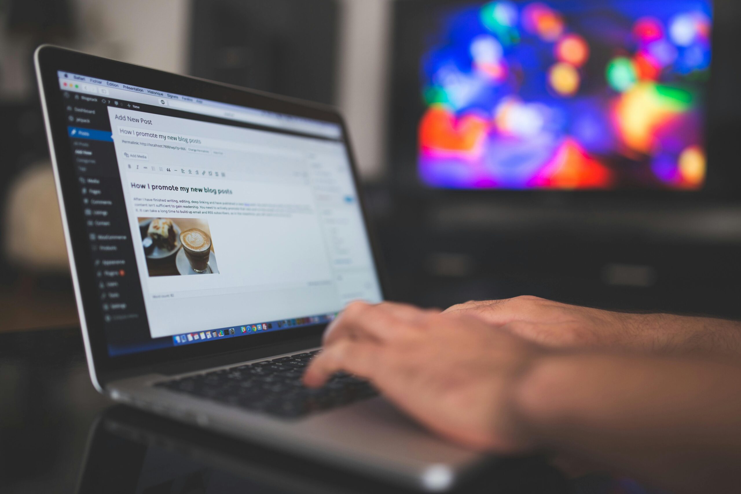 Person typing on a laptop, creating and managing digital content with a website editor.